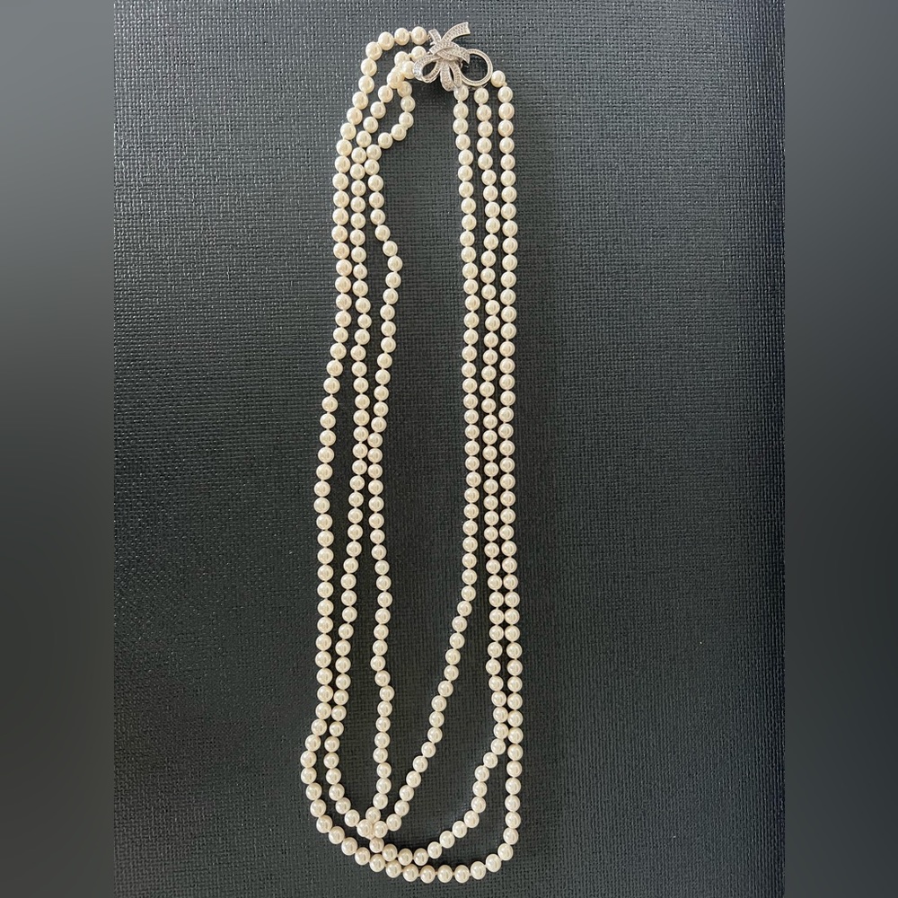 3 string nesting faux pearl necklace with platinum color and faux diamond bow.
